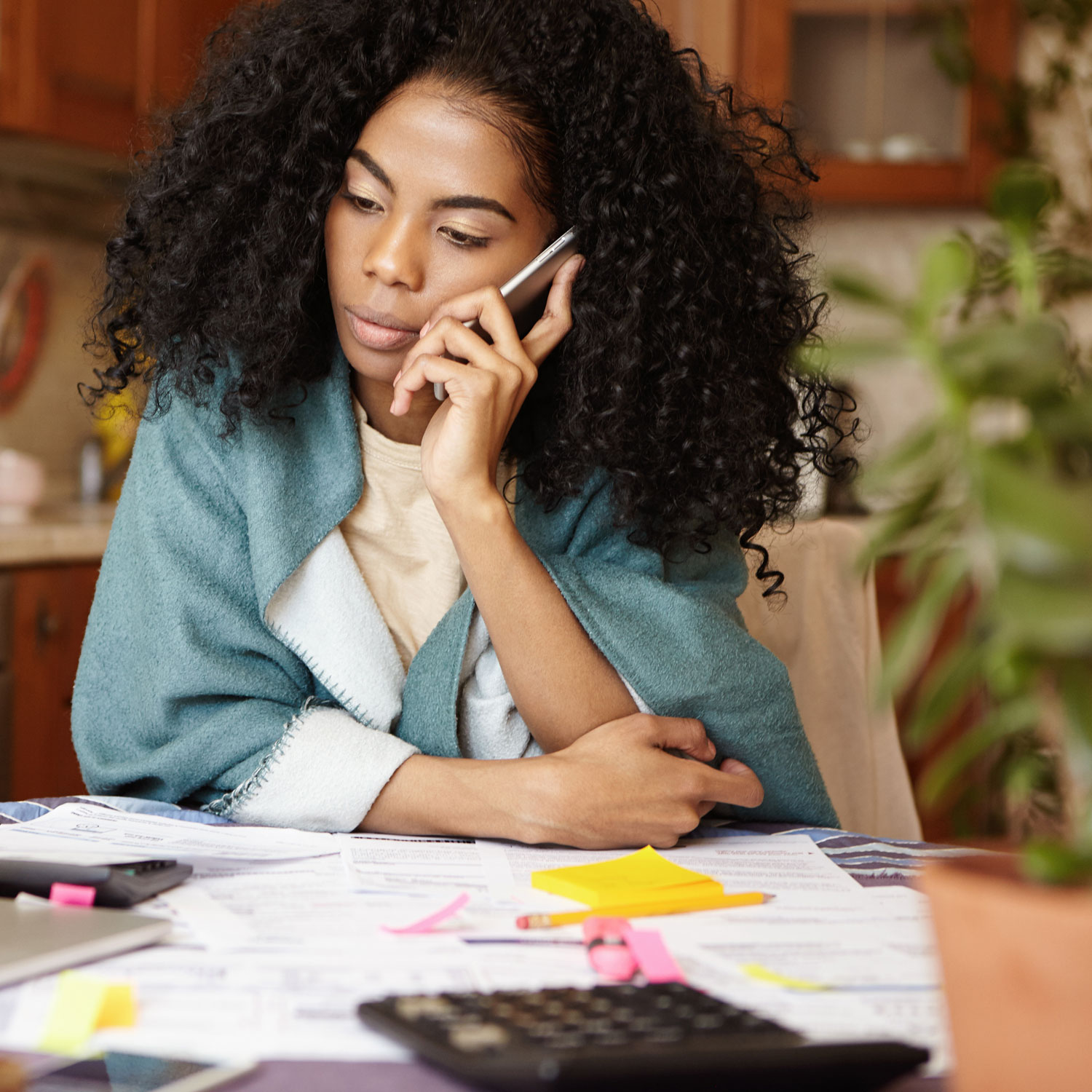 Woman on phone looking at bills.